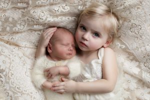 Children snuggle during their photo session and newborn portraits. 